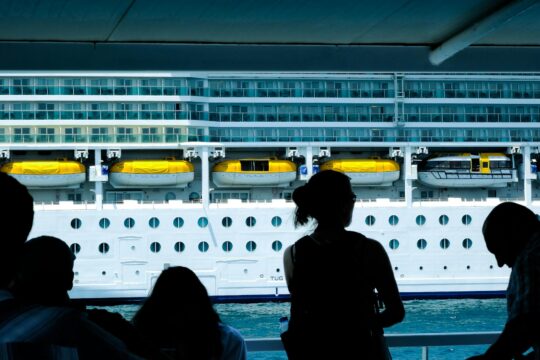 cruise ship injury — Silhouettes of people observing a large cruise ship from a dock in Türkiye.
