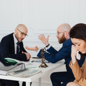 Wrongful death lawyer (A woman appears distressed while two lawyers converse in an office.)
