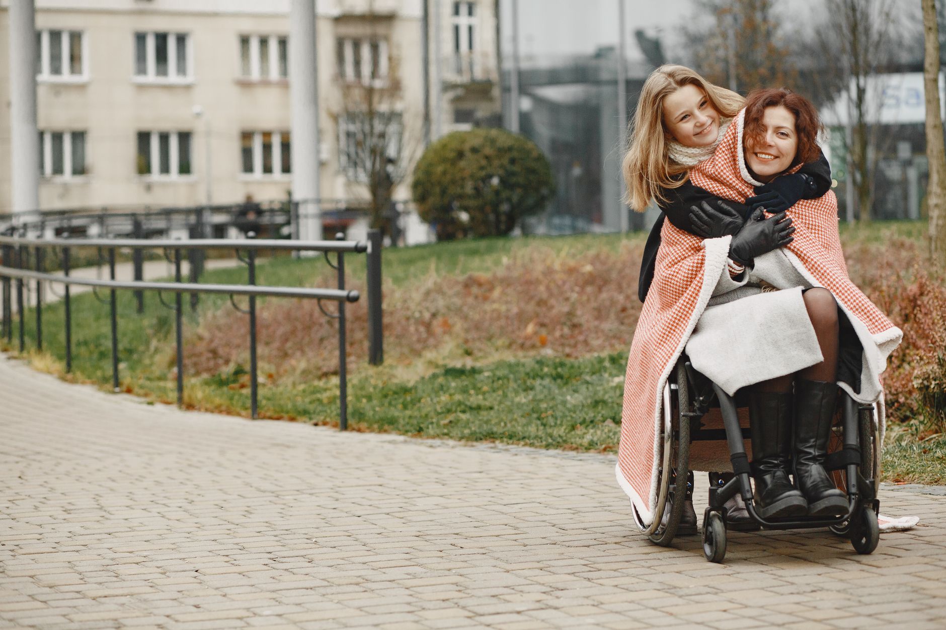 Spinal cord injury lawyer (Mother and daughter share a warm embrace in a park, highlighting love and mobility support.)