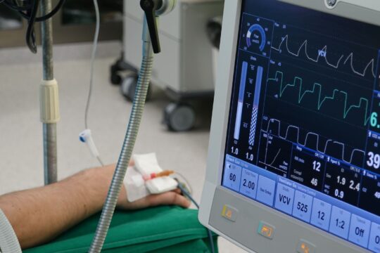 Workplace injury statistics 2026 (A close-up of a patient's hand connected to medical equipment in an ICU room.)