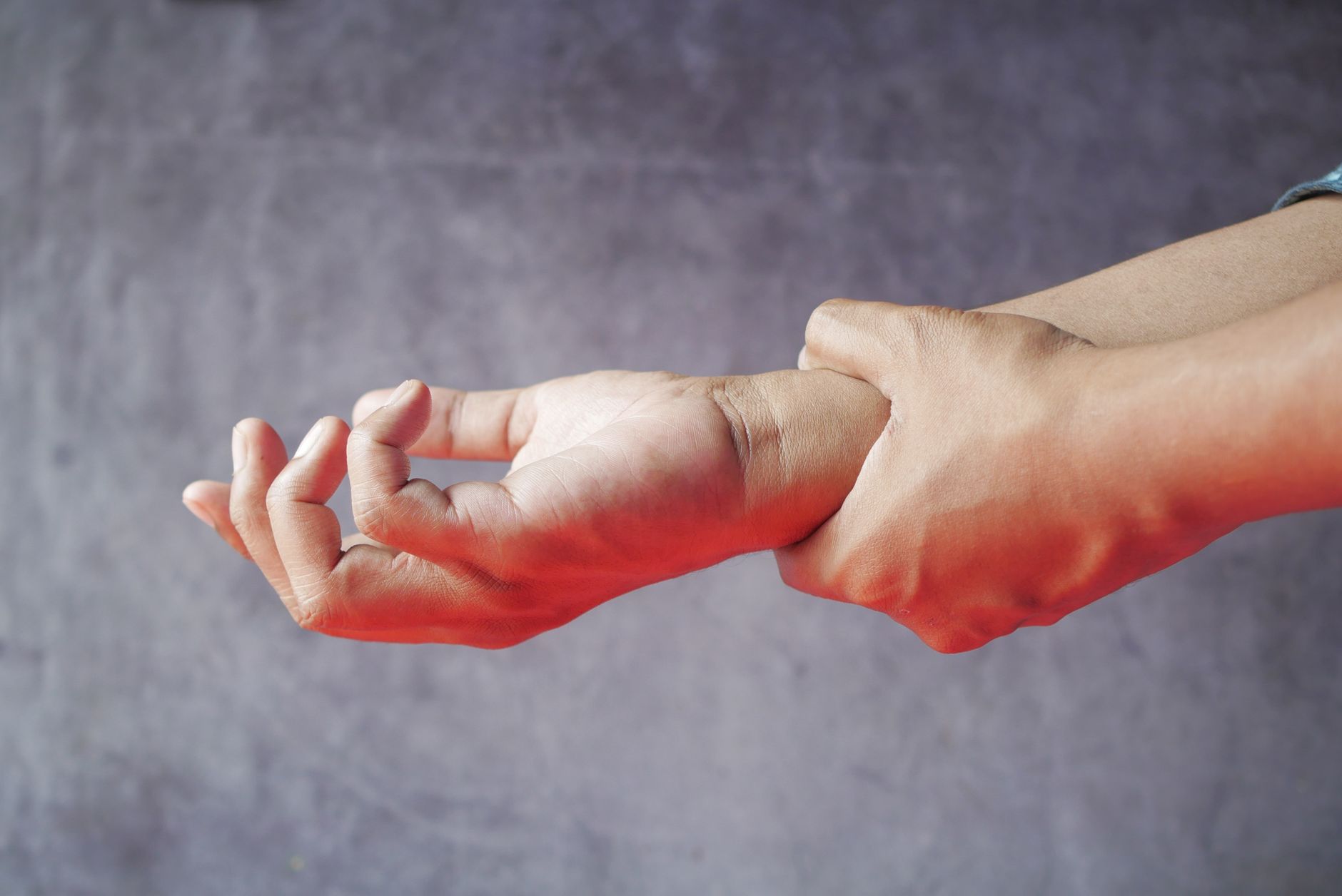 Repetitive stress injury workers comp (Close-up of hands, one grasping the other, symbolizing pain or discomfort.)