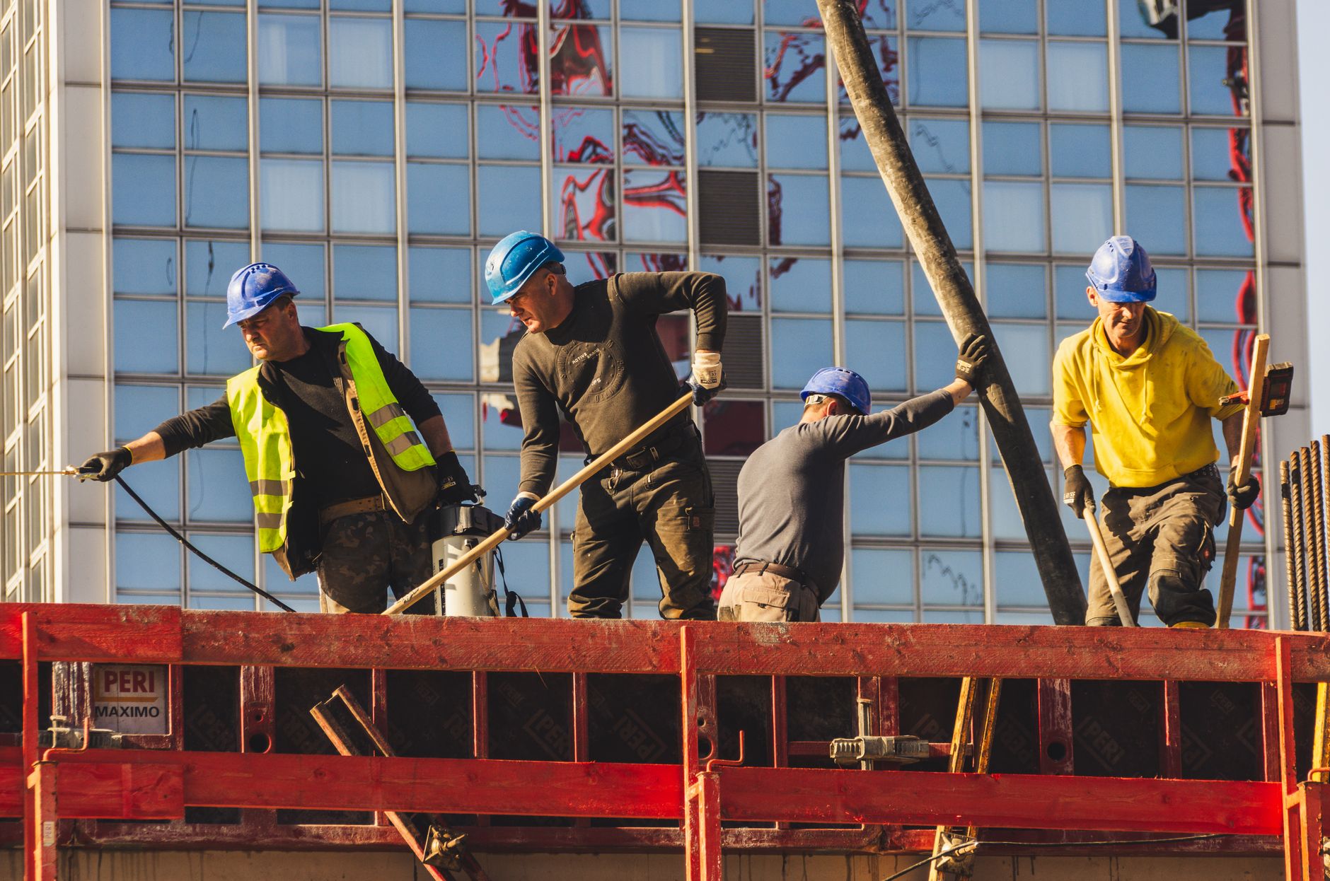 Workers comp denial appeal (A group of construction workers in safety gear actively working on a high-rise building site.)