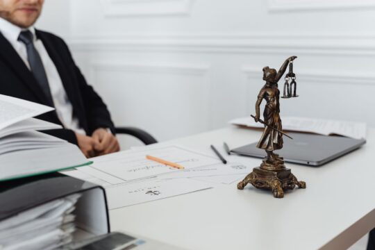 Personal injury law firm (A legal professional's workspace featuring Lady Justice statue, documents, and a laptop.)