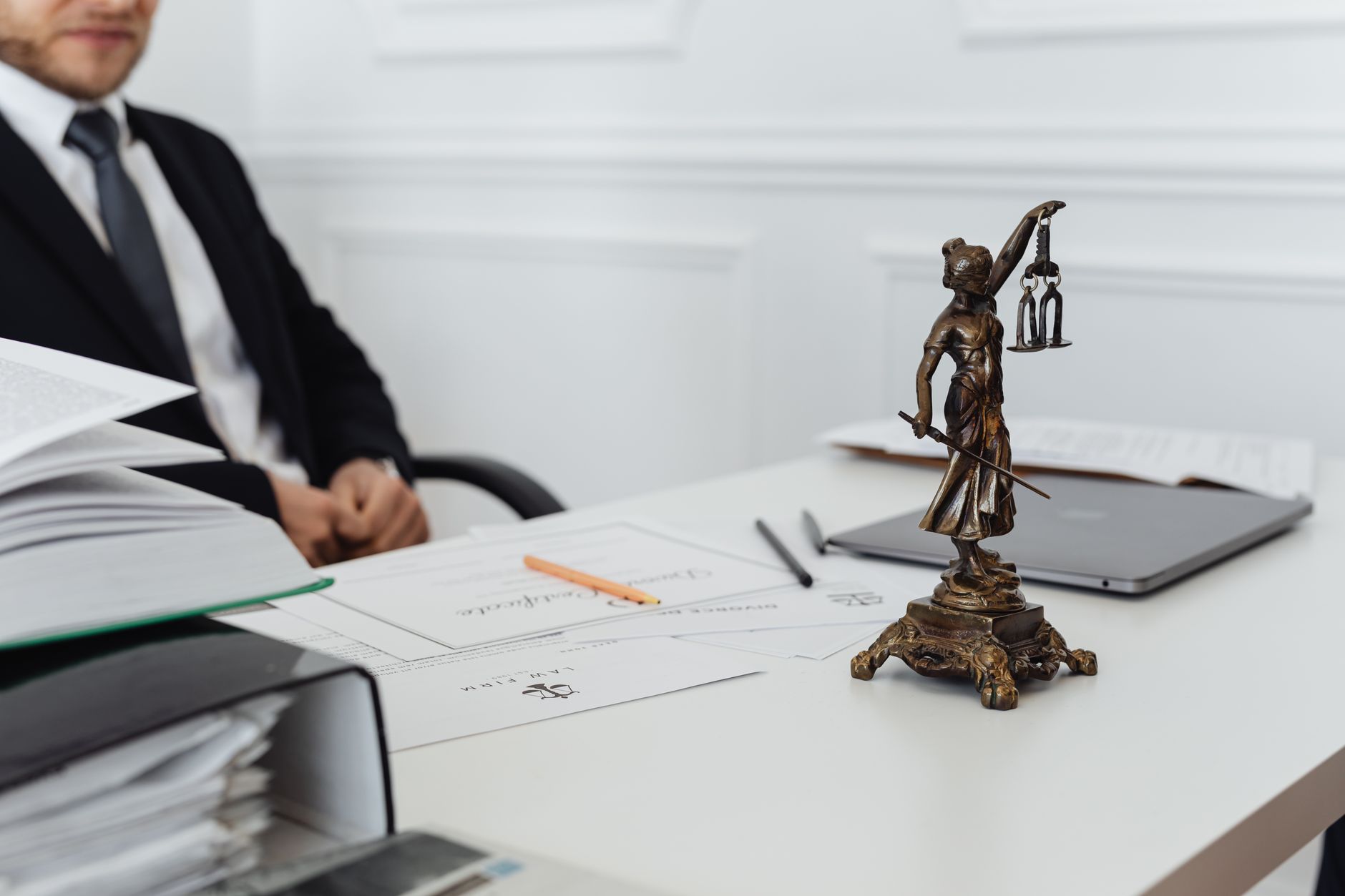 Personal injury law firm (A legal professional's workspace featuring Lady Justice statue, documents, and a laptop.)