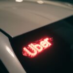 Uber accident lawyer (Close-up of a ride-sharing car with a bright red illuminated sign for night-time travel.)