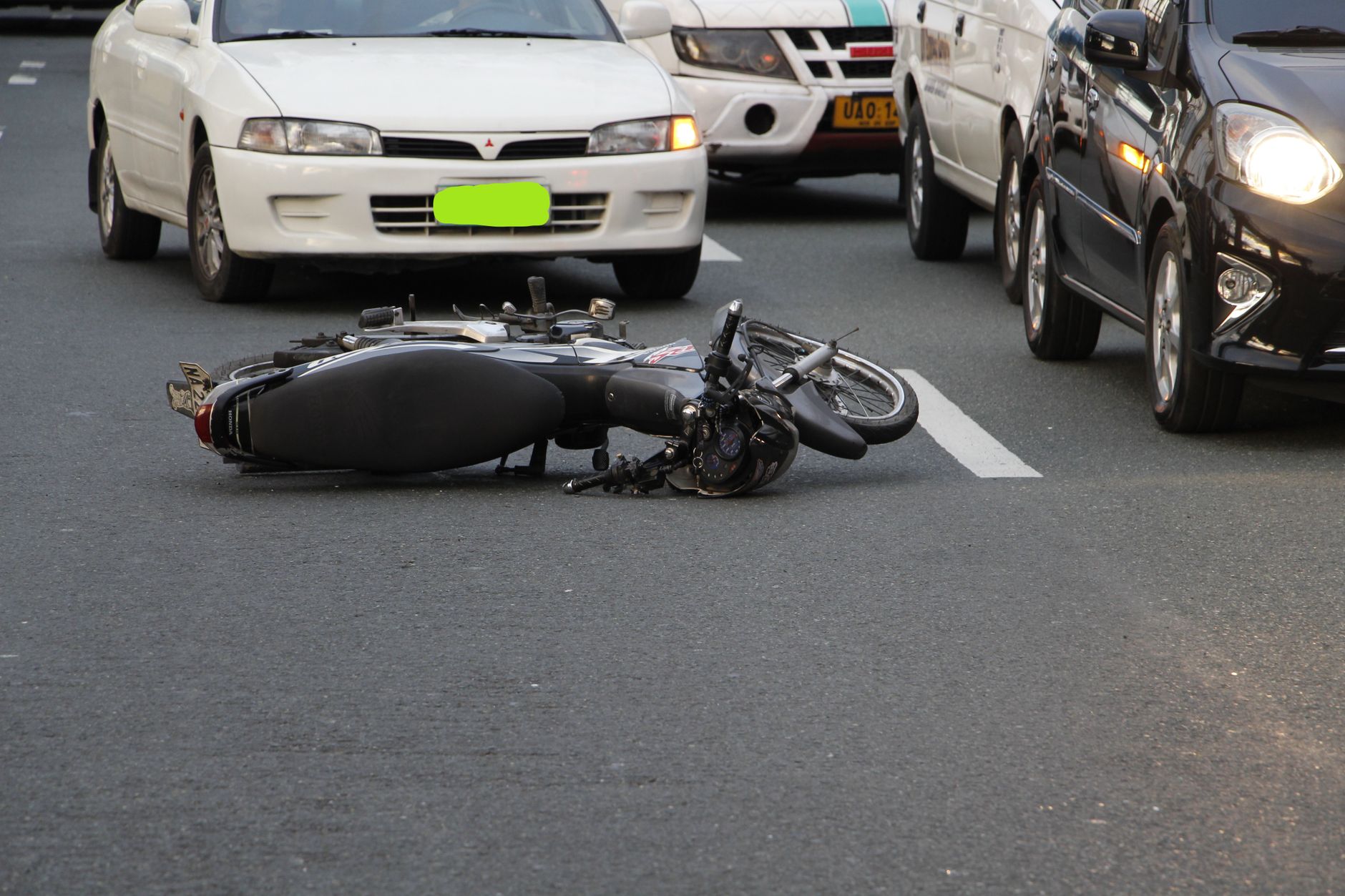 Hit and run accident lawyer (A motorcycle lies on a city road amidst traffic, indicating a recent accident.)