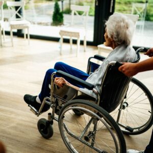 Nursing home abuse lawyer (A caregiver assists a senior adult in a wheelchair at a nursing home in Prague, Czech Republic.)